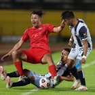 Andrés López (d), de Universidad Católica, disputa un balón con Carlos Ferreira, de Libertad.