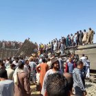 Tahta District (Egypt), 26/03/2021.- People stand atop a turned over train carriage as others inspect the scene of a train crash in Sohag province, Egypt, 26 March 2021. At least 32 people were killed and some 66 injured as two passenger trains collided in the Tahta district in Sohag governorate, the Health Ministry announced. (Egipto) EFE/EPA/STRINGER At least 32 dead in train collision in Sohag