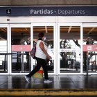 Una mujer camina frente a la puerta cerrada de la sección de "Salidas" del aeropuerto en Buenos Aires (Argentina).