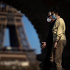 Paris (France), 31/03/2021.- Pedestrians wearing protective face masks enjoy the warm spring weather as they walk across the Bir Hakeim bridge near the Eiffel Tower, hours before French President Emmanuel Macron is due to make a televised address to the nation to announce enhanced measures to fight the spread of Covid19 coronavirus as France faces a third wave of the pandemic, in Paris, France, 31 March 2021. (Francia) EFE/EPA/IAN LANGSDON