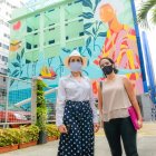 La gerente de la Empresa Pública de Turismo, Gloria Gallardo (i), frente a un mural de la calle Panamá.