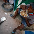 Henrique Silva, de 22 años, almuerza tras recibir una donación de comida en la calle da Paz, el 2 de abril de 2021 en la favela de Paraisópolis, en Sao Paulo (Brasil).