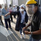 Un hombre recibe instrucciones para encontrar su puesto de votación hoy, en un colegio electoral del distrito de Villa El Salvador, en Lima.