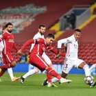 Firmino, del Liverpool, intenta rematar ante la marca del madridista, Militao.