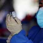 Un miembro del personal de salud sostiene una dosis de la vacuna contra la covid-19 del laboratorio Astrazeneca durante una jornada de vacunación en Quito (Ecuador).