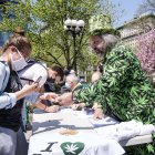 El voluntario Todd Hinden (R) reparte cigarrillos de marihuana a todo aquel que pueda demostrar que ha sido vacunado contra el COVID-19.