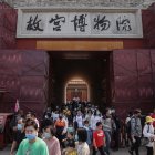 Los turistas caminan fuera de la Ciudad Prohibida en Pekín, China.