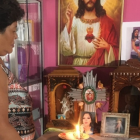 Nube Dolores mantiene todo el día una vela encendida por su hija Johanna Tapia. Su foto está en medio de varias imágenes de santos.