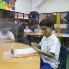 Desde sus pupitres a dos metros de distancia y separados por mamparas, los alumnos del Balandra Cruz del Sur cruzan miradas entre ellos.