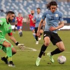 Claudio Bravo, arquero de Chile, trata de obstaculizar una acción de Edinson Cavani, delantero uruguayo.