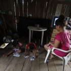 Moisés y Judith, hijos de María Fernanda Orellana, juegan en el piso de su humilde vivienda al no tener labores escolares que hacer porque no están en la escuela.