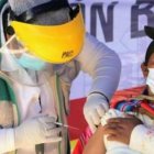 Un médico vacuna a una indígena boliviana.