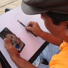 Édgar Jaime pintando un retrato que el cliente le envió por Whatsapp, en estos tiempos de pandemia.