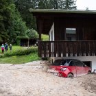 Un coche aparece semienterrado por las inundaciones en Schoenau am Koenigssee, Alemania.