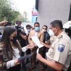 Quito. Tania Castillo pide a un policía que le permita el ingreso a la entidad. Pero las puertas fueron cerradas.