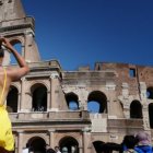 Una turista con ropa ligera visita el Coliseo Romano.