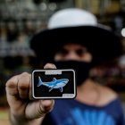 Una turista muestra un imán con la imagen de un tiburón, el 12 de agosto de 2021, en Jaboatao dos Guararapes (Brasil).