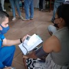 La venezolana Jéssica Castillo es valorada por un médico antes de aplicarle la vacuna.