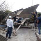 Un grupo de habitantes de Valdivia recogen los escombros del techo que se cayó en el museo del lugar.