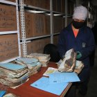 Vicente Celi limpia la ceniza de uno de los archivos quemados.