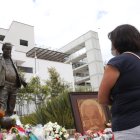Una fanática de Liga de Quito frente a la estatua de Rodrigo Paz, exdirigente de Liga de Quito.
