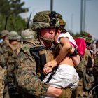Fotografía facilitada este lunes por el Departamento de Asuntos Públicos del Comando Central de EE.UU., a través de DVIDS, en la que se registró el pasado viernes a un infante de marina estadounidense al trasladar a una niña, en la puerta del aeropuerto internacional Hamid Karzai, en Kabul (Afganistán).