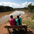 En junio de 2020, una pareja de indígenas del pueblo de Mayuruna cruiserinho, sentados en un banco a orillas del río Javari en Palmeiras do Javari, en la frontera con Perú. Brasil, la principal reserva hídrica del mundo, perdió más de tres millones de hectáreas en áreas cubiertas de agua dulce en 30 años.