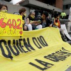 Una mujer muestra un cartel que detalla el número 6.402, cifra aludida a las víctimas de los llamados "falsos positivos".