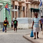 Varias personas con tapabocas caminan por una calle, en La Habana (Cuba).