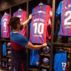 Un empleado de la Barça Store Camp Nou coloca la nueva camiseta del delantero del Barcelona, Ansu Fati, que se convierte en el heredero del dorsal 10 de Leo Messi