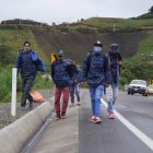 Grupos de migrantes venezolanos caminan por una carretera en la región de Tulcán (Ecuador).