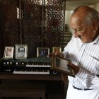 El ingeniero Fernando Córdova mira fotos del recuerdo, de es época en que trabajó para inspeccionar la instalavión de tubería en Urdesa, en el siglo pasado.