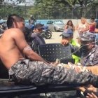 Un agente de la Policía herido es retirado del sector en ambulancia.