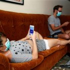 Imagen de archivo de dos jóvenes revisan sus teléfonos celulares dentro de su casa durante la cuarentena por la pandemia de covid-19 en La Habana (Cuba).