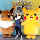 Una chica posa con Pikachu y Eevee en foto de archivo.