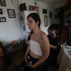 Sandra Monroy (i), recibe ayuda de Gina Ramírez (d), en su habitación el 30 de septiembre de 2021, en la Ciudad de México, tres meses después de que se le practicara una masectomía bilateral a causa del cáncer de mama que padecía.