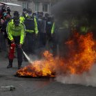 Policías intentan extinguir el fuego de unas barricadas en una carretera, encendido por indígenas que protestan para exigir la derogación del alza en los precios de los combustibles, en Pujilí, provincia de Cotopaxi (Ecuador).