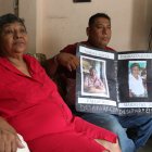 Reclamo. Roberto Farías muestra, junto a su tía, un cartel con la foto de su madre saparecida desde la pandemia.