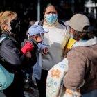 Venezolanos esperan antes de abordar un bus hoy viernes, frente al consulado de su país en Quito.