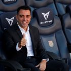El nuevo entrenador del FC Barcelona, Xavi Hernández, posa en el banquillo del Camp Nou tras finalizar el acto de presentación como entrenador blaugrana.