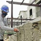 TRABAJADOR ALBAÑIL MIENTRAS CONSTRUYE UNA CASA EN UN PROYECTO HABITACIONAL |