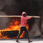 Un hombre camina junto a un neumático gigante en llamas durante una jornada de protestas en Haití, en una fotografía de archivo.