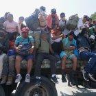 Migrantes centroamericanos abordan camiones, para continuar con su caravana hacia EEUU, este viernes en la comunidad de Santiago Niltepec, en el estado de Oaxaca (México).