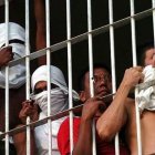 Un grupo de personas privadas de la libertad, tras las rejas.