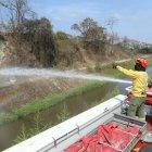 Una llanta envuelta en llamas es apagada por los bomberos en la cooperativa Janeth Toral.