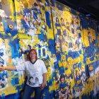 Mariana Vega, integrante de la Iglesia Maradoniana, junto a un mural del astro que pintó Boca Juniors.