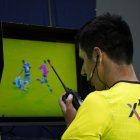 El juez Luis Quiroz se comunica con los árbitros del VAR por una acción dudosa.