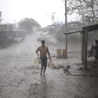 ARCHIVO - Un migrante lleva bajo intensa lluvia un bidón de agua potable a un depósito que sirve de refugio para migrantes en el Tapón del Darién. Foto: Mauricio Valenzuela/dpa ag-periodistas