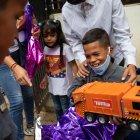 Un niño reacciona luego de abrir un regalo de "Un Juguete, una buena noticia" , en Caracas (Venezuela). EFE/ RAYNER PEÑA R.
