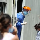 Personal de salud atiende a personas que acuden a realizarse una prueba para detectar la covid-19 en el Hospital Pedro Elizalde, hoy, en Buenos Aires (Argentina). Argentina vive una "tercera ola" de la pandemia marcada por cifras récord de contagios de la variante ómicron, una situación que está colapsando los principales centros de testeo y los sistemas de atención primaria, mientras el Gobierno opta por no imponer restricciones que frustren las vacaciones de verano.